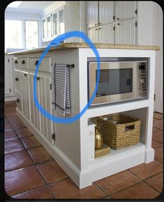 a microwave oven sitting on top of a kitchen counter next to a basket and towel rack