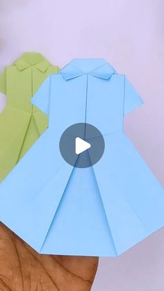 an origami shirt being folded on top of someone's hand with the video below it