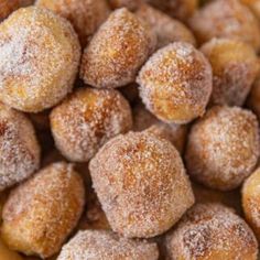 powdered sugar coated doughnuts in a wooden bowl