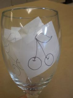 a wine glass that has been decorated with sticky notes and a bicycle drawn on it