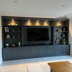 a large entertainment center with built - in shelves and lights on the wall, along with a flat screen tv