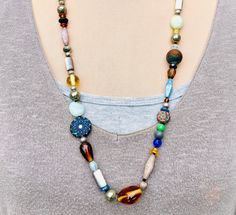 Funky mixed knotted bead necklace with every color in the Rainbow.  This colorful over the head necklace is 28 inches in length and includes Glass, Czech Glass, Gemstones, Wood and Metal beads.  Earthy Boho, Festive Organic Beaded Necklace, Eclectic, Rustic, Modern Hippie, hand knotted, Rainbow necklace. Statement necklace. Bold color necklace. Bright multi color necklace. Handmade necklace. Unique gift For more unique jewelry visit: majidesignsjewelry.com  Shipping is FREE in the USA! My turnaround time is 1-2 days. I ship 1st class mail.  Any additional questions:  Majidesignsjewelry@gmail.com Mixed Beads Necklace, Modern Hippie, Multi Coloured Necklaces, Head Necklace, Rainbow Necklace, Color Necklace, Necklace Chunky, Necklace Unique, Necklace Statement