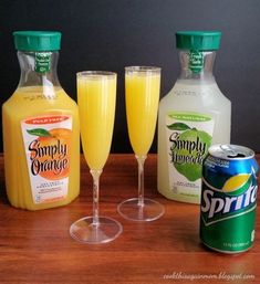 some drinks are sitting on a table next to two bottles and an empty glass with orange juice in it