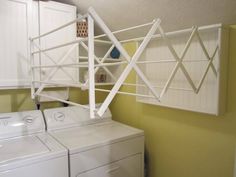 a washer and dryer sitting next to each other in a room with yellow walls