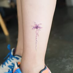 a woman's foot with a flower tattoo on the left side of her leg