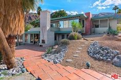 this is an image of a home in palm springs, california with rocks and trees