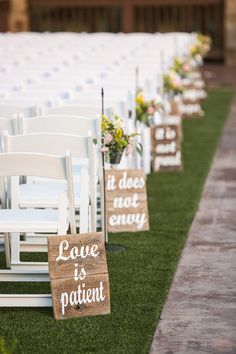 rows of white chairs with wooden signs on them