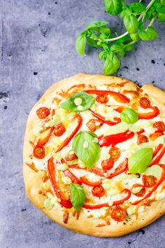 a pizza sitting on top of a pan covered in cheese and veggie toppings