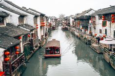 a boat traveling down a river surrounded by buildings