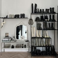 a room filled with lots of different types of shoes on shelves next to a mirror