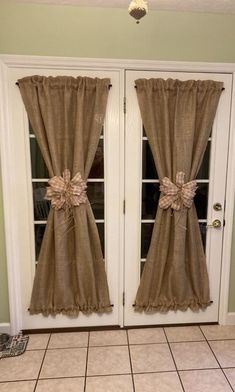 the front door is decorated with burlock and bow tie curtains for added color