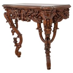 an ornate wooden table with carvings on the top and bottom, against a white background