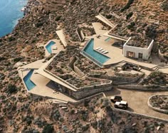 an aerial view of a house on the side of a hill with a swimming pool