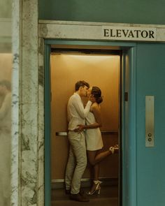 a man and woman kissing in an elevator