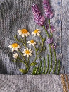 some flowers are sitting in the pocket of someone's jean jacket, which has been stitched together