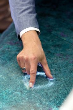 a person's hand on top of a piece of cloth