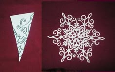 two paper snowflakes sitting on top of a red table next to each other