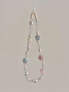 a necklace with pearls and hearts hanging from it's end on a hook in the shape of a tear