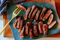 sliced up steak on a cutting board with a fork