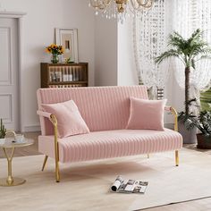 a living room with a pink couch and chandelier