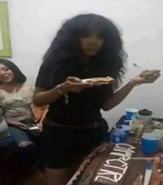 two women sitting at a table eating cake