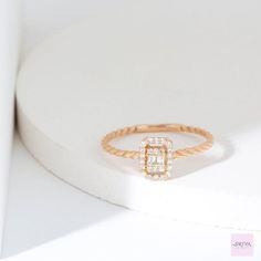 a diamond ring sitting on top of a white surface