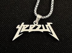 a necklace with the word metallic on it and an image of a guitar picker