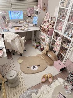 a room filled with lots of toys and stuffed animals on the floor in front of a computer desk