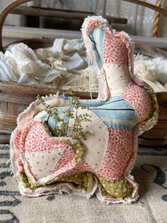 a stuffed animal sitting on top of a rug next to a basket filled with cloth