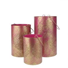 three pink and gold canisters sitting next to each other on a white background