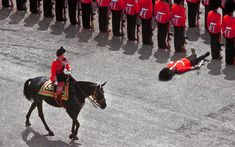 a man in red riding on the back of a horse next to a group of people