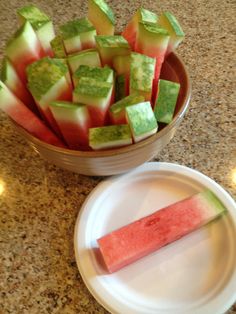 watermelon slices cut in half on a plate next to a bowl of sliced watermelon