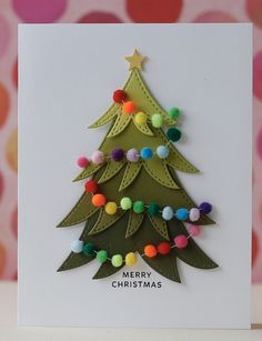 a christmas tree card with pom - poms on the bottom and an ornament in the middle