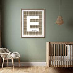 a baby's room with a crib, rocking chair and framed letter e