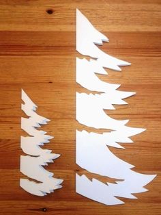 cut out paper trees sitting on top of a wooden table