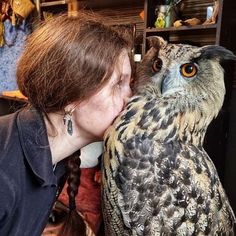 a woman kissing an owl on the nose