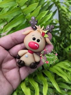 a hand holding a tiny toy with a reindeer on it's head and nose