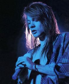 a woman with long hair holding a microphone