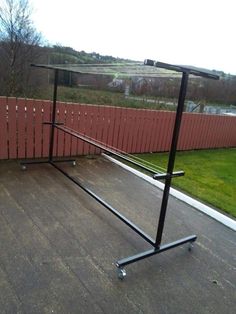 a black metal pole sitting on top of a wooden floor next to a red fence