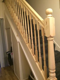 a wooden banister next to a white door