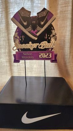 a display case with a nike logo on it and a purple ribbon around the top