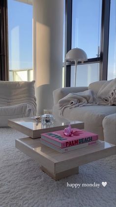 a living room filled with furniture and a window next to a white couch covered in blankets