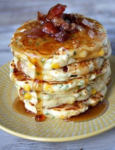 a stack of pancakes with bacon on top