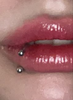 a woman's lips with piercings on them