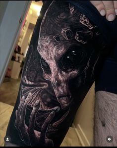 a man's leg with a tattoo on it that has a skull in the middle