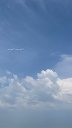 two people are flying kites on the beach under a blue sky with white clouds