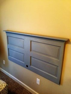 a gray headboard with two doors on it