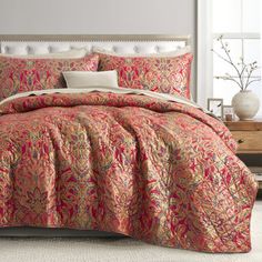 a bed with a red and gold comforter