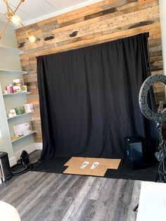 a photo studio with black backdrop and wooden walls