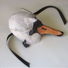 a white and brown duck with black headbands sitting on top of a table